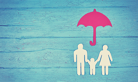 berufsunfaehigkeitsversicherung familie aus papier geschnitten unter regenschirm auf blauem hintergrund mit holzstruktur